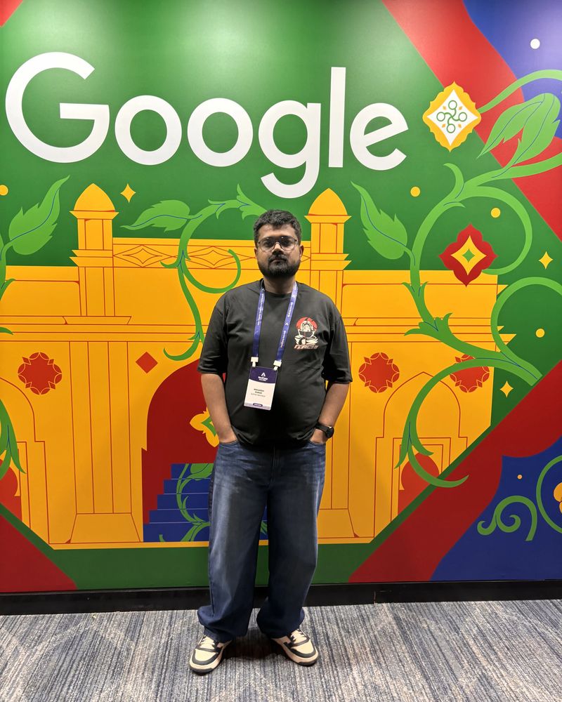Maharshi Kushwaha in front of a colourful Google mural at WordCamp Asia